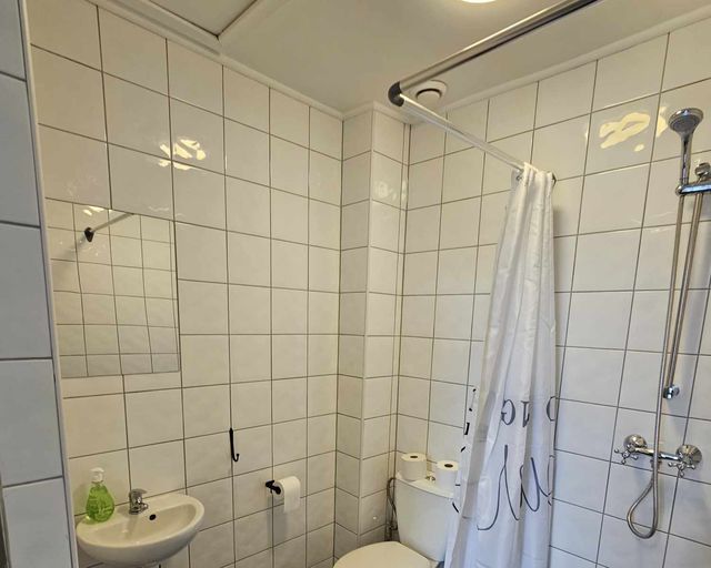 Eget badrum med dusch, handfat och toalett i vitt kakel